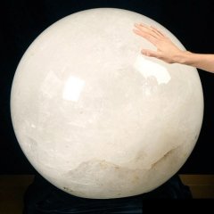 Giant quartz crystal ball with hand touching it