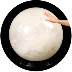 Giant quartz crystal ball with hand touching it
